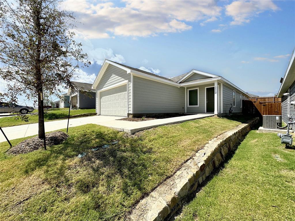 a view of a house with backyard and tree