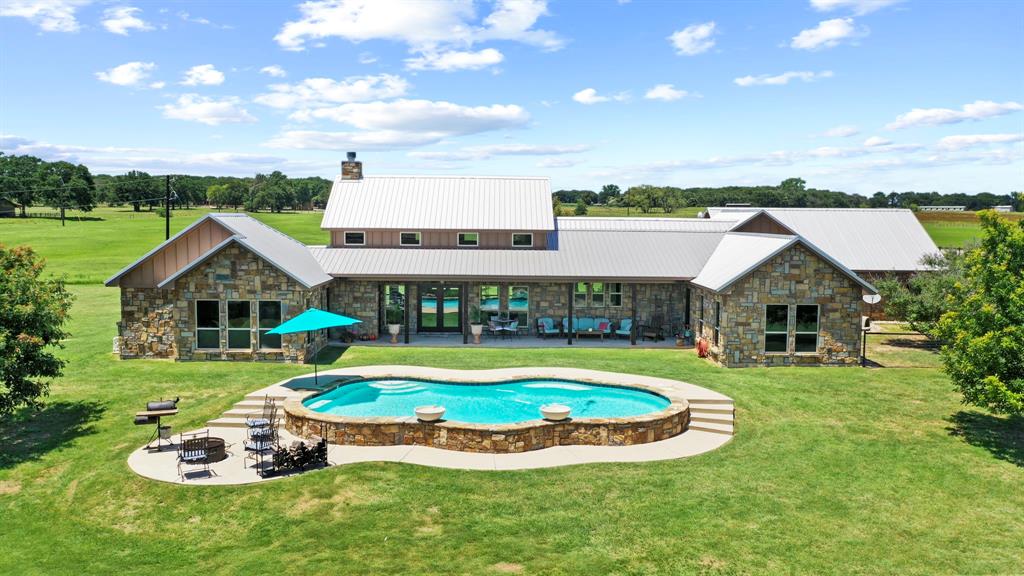 a view of a house with swimming pool and a yard