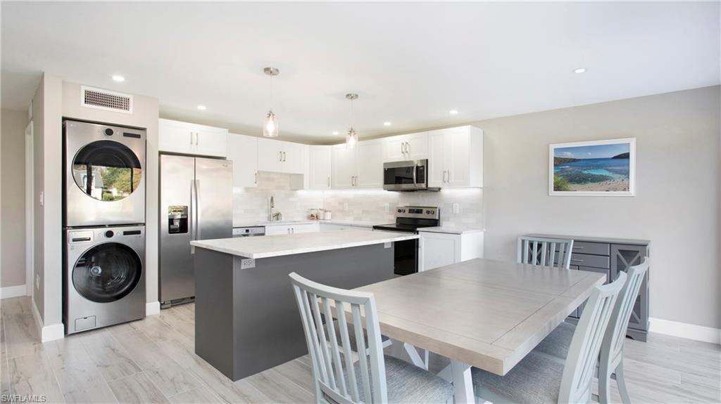 a kitchen with kitchen island a stove a table and chairs