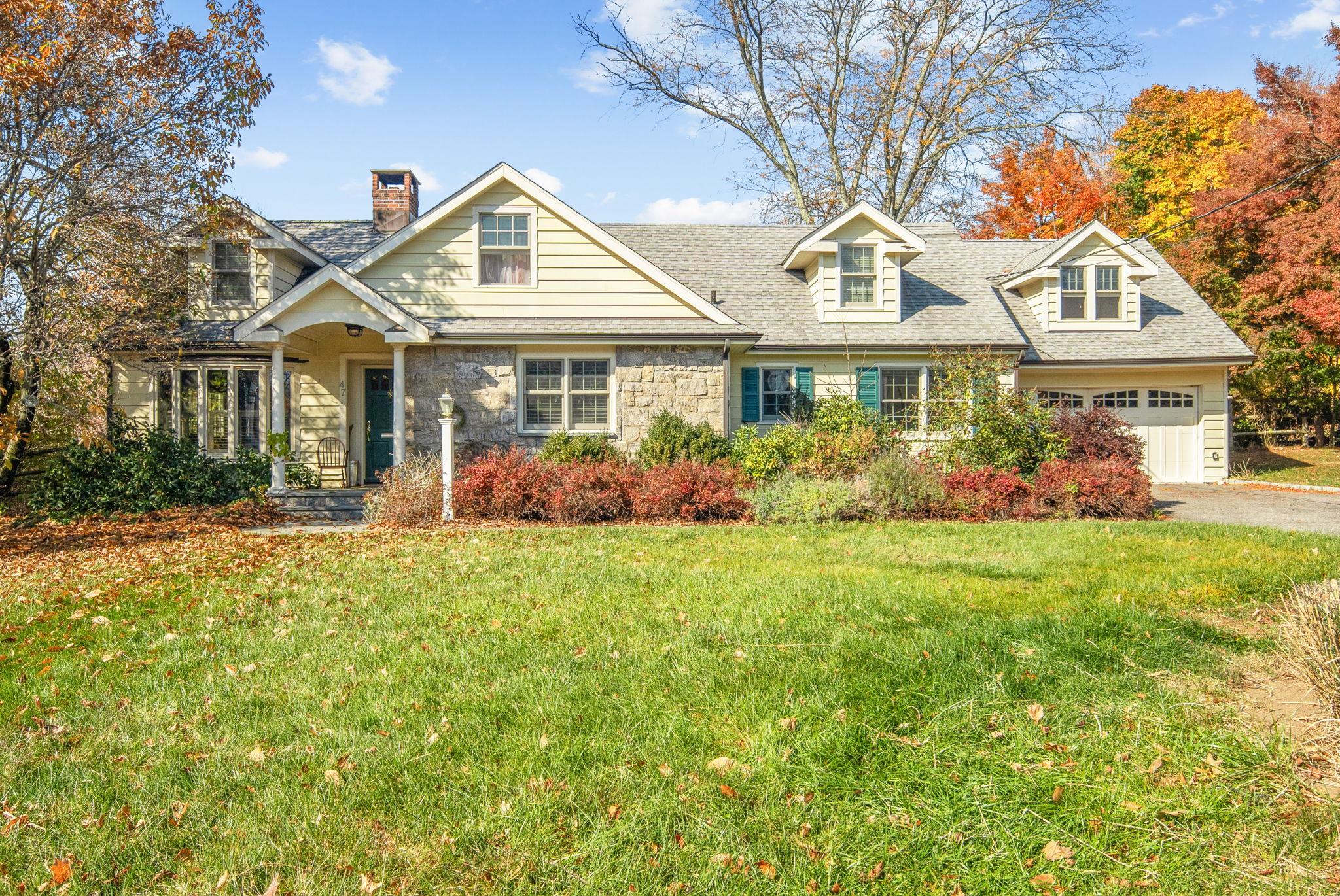 View of front of property with a garage and a front lawn