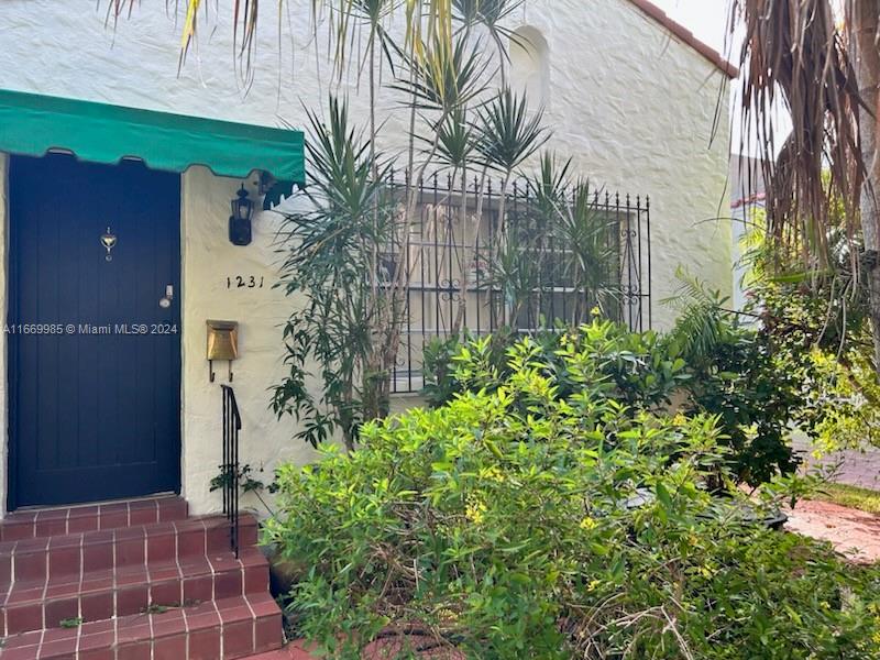 a backyard of a house with potted plants and a bench