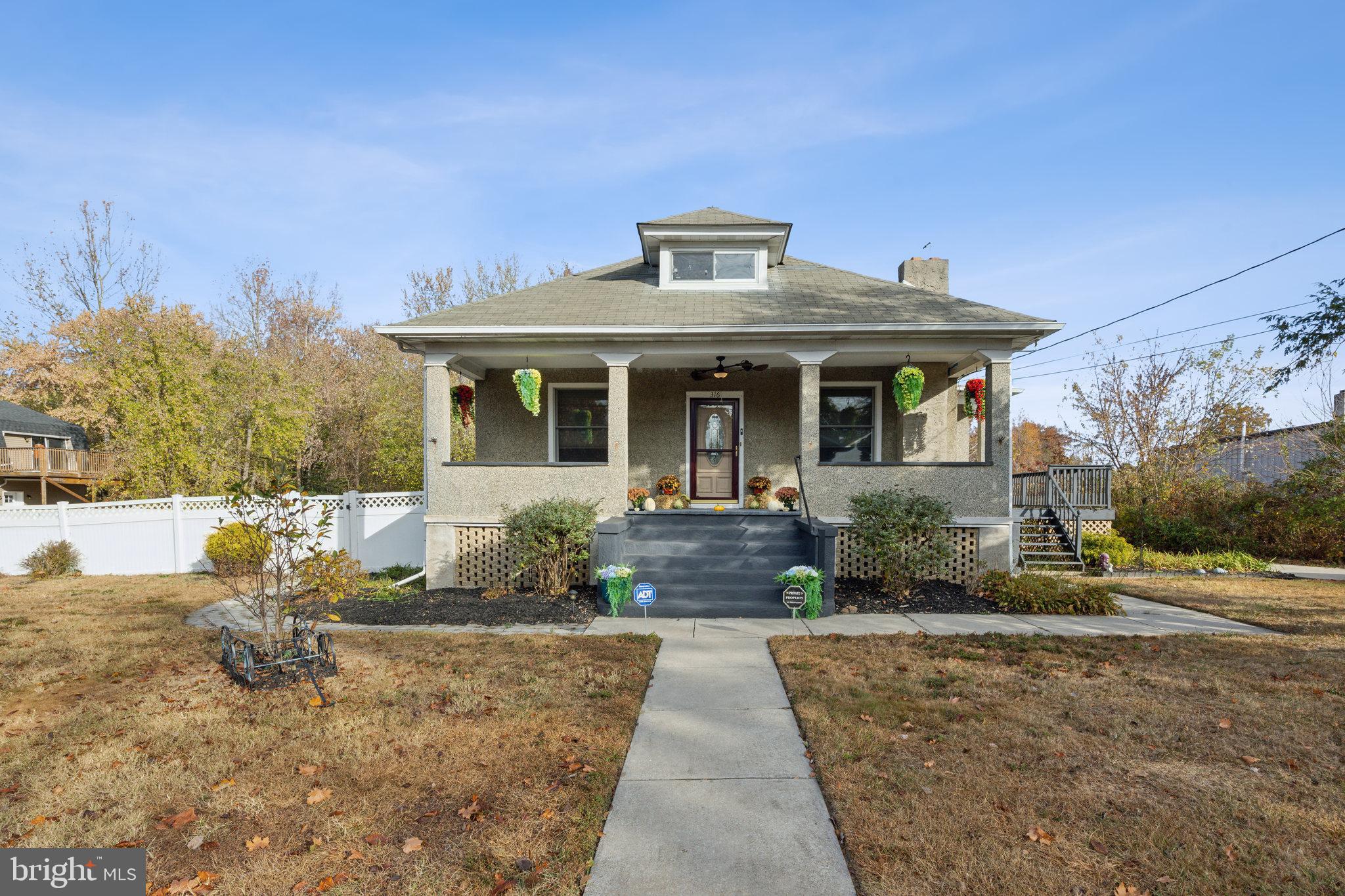 a front view of a house with a yard and potted plants