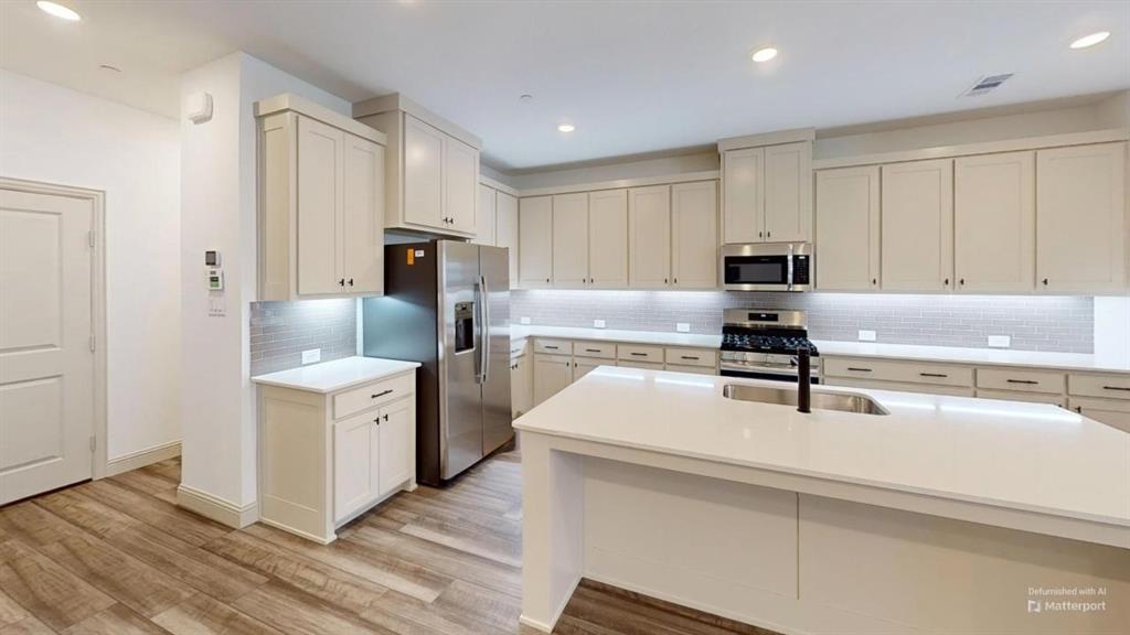 a kitchen with kitchen island white cabinets appliances and sink