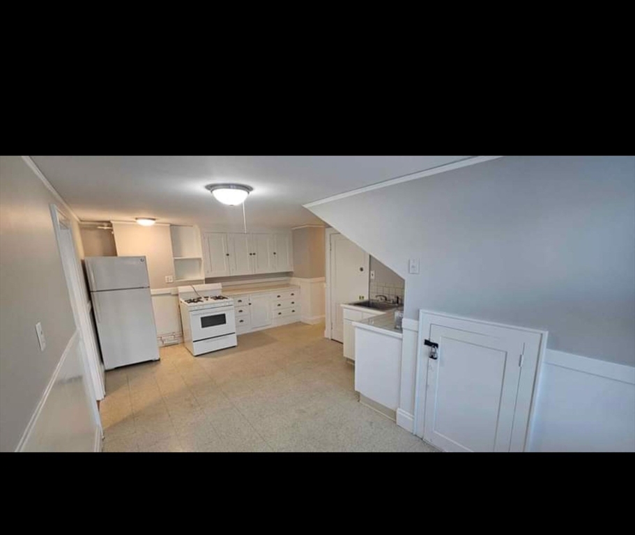 a view of a kitchen with white cabinets