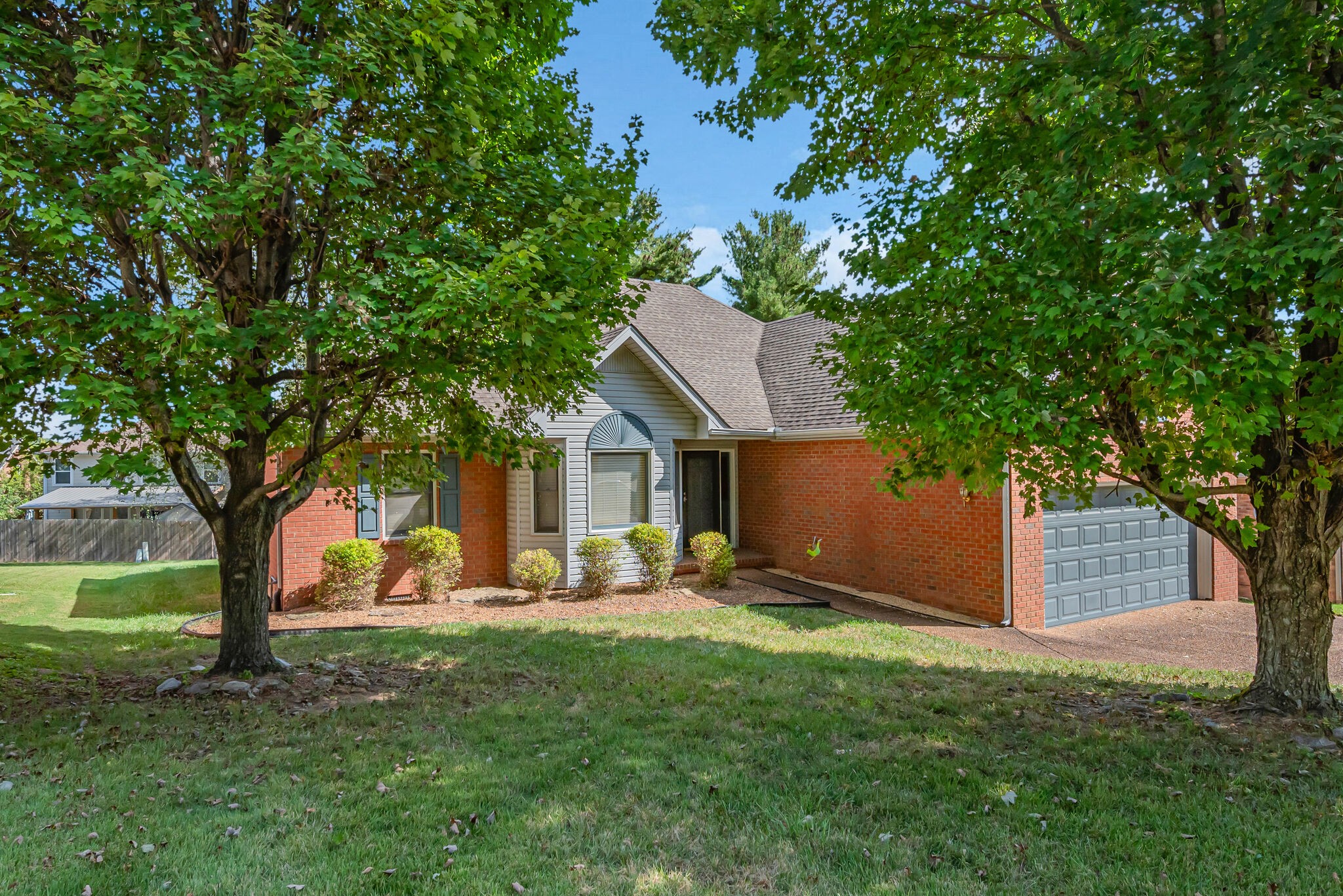 a view of a house with backyard and a tree