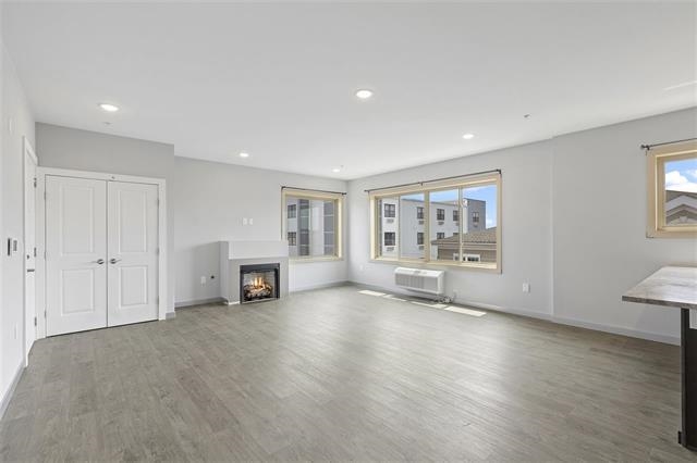 a view of a big room with wooden floor and windows