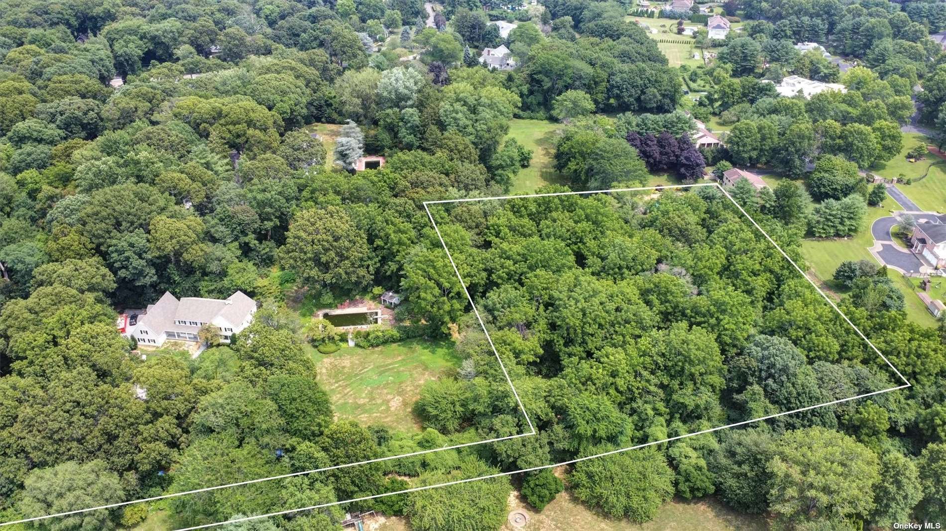 a backyard of a house with lots of green space and lake view