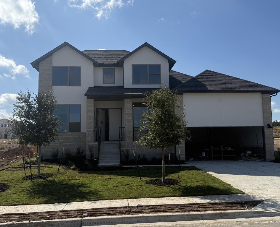 a front view of a house with a garden and yard