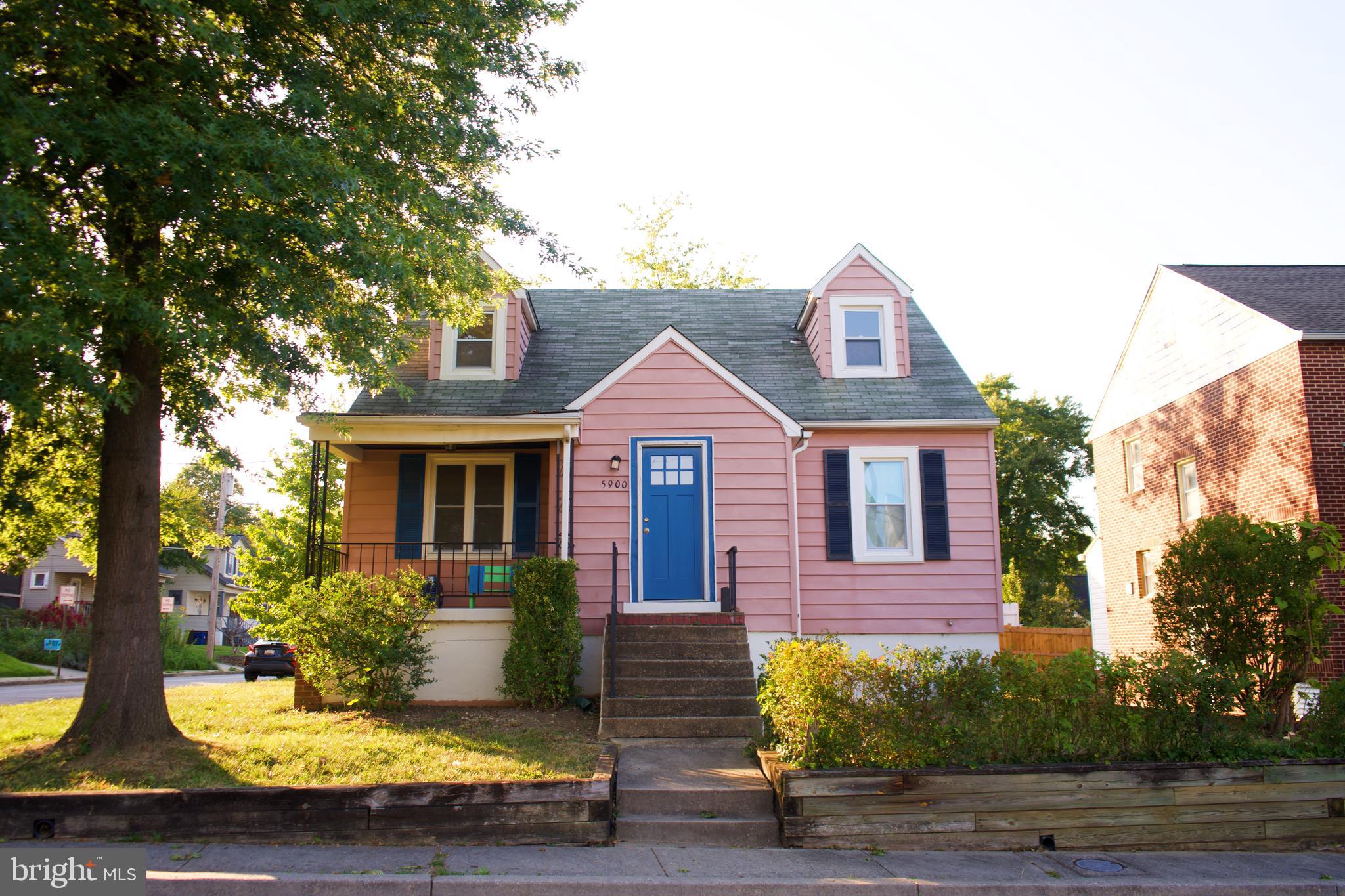 a view of a house with a small yard plants and large tree