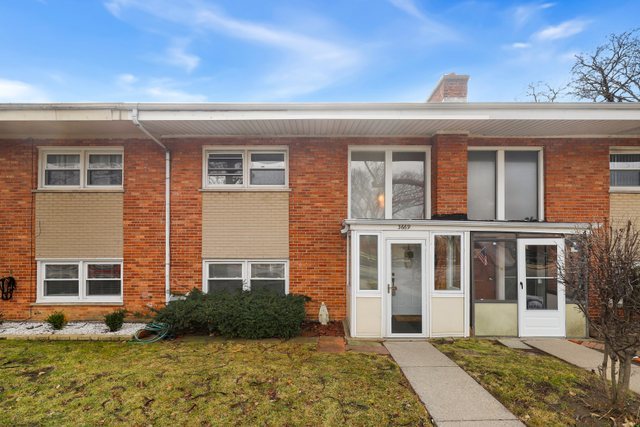 a view of a brick house with many windows