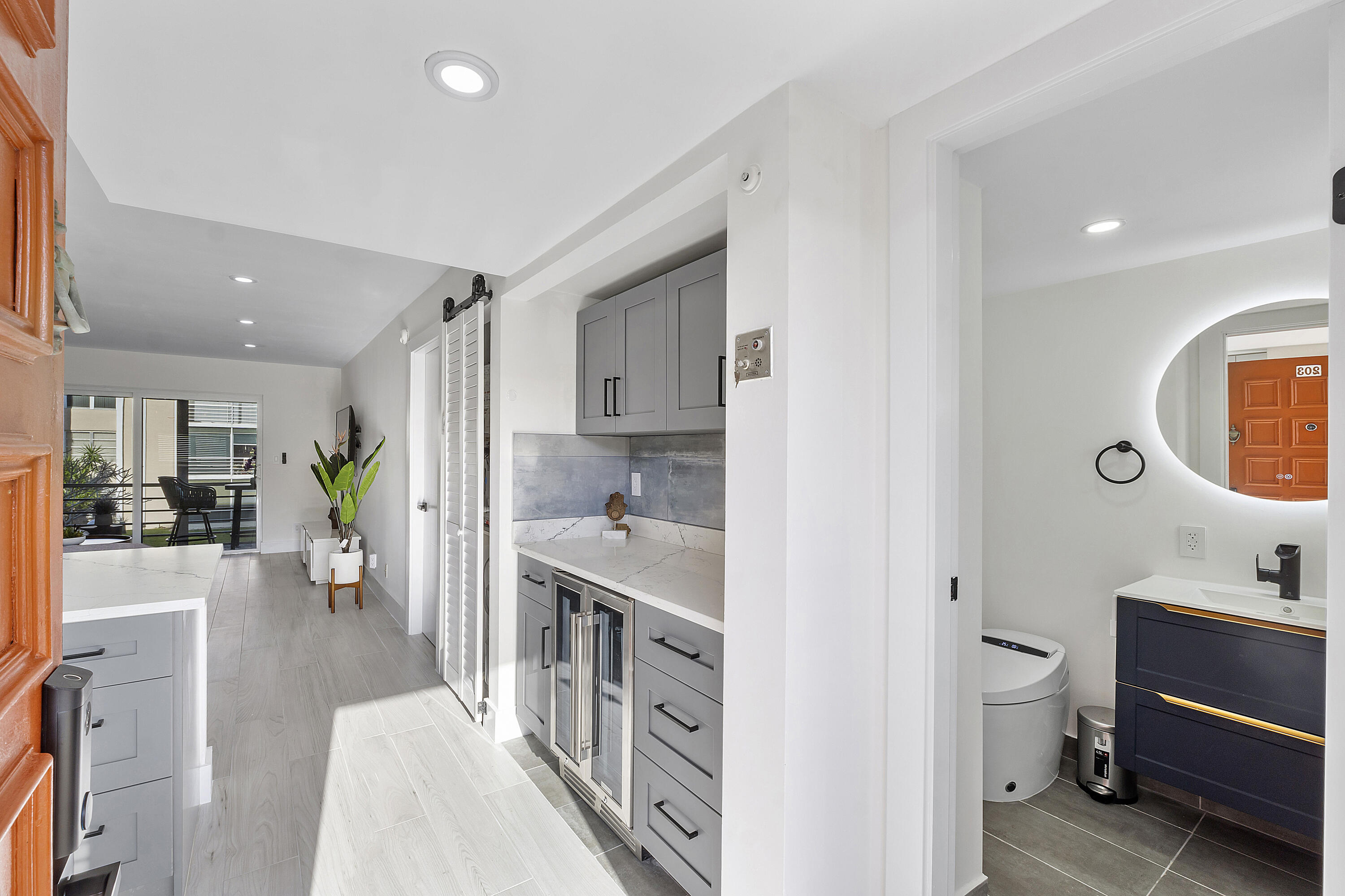 a large white kitchen with a lot of counter space and wooden floor