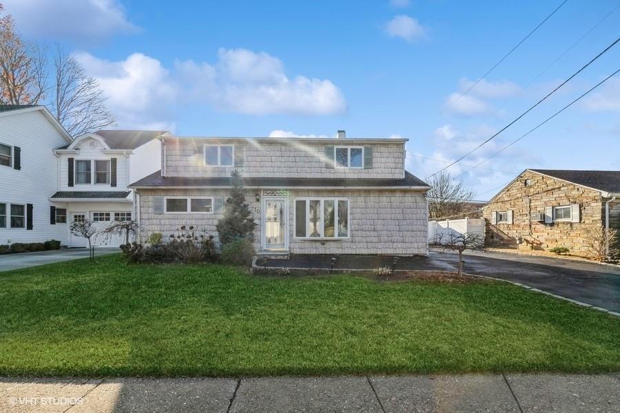 View of front of property featuring a front yard and a garage