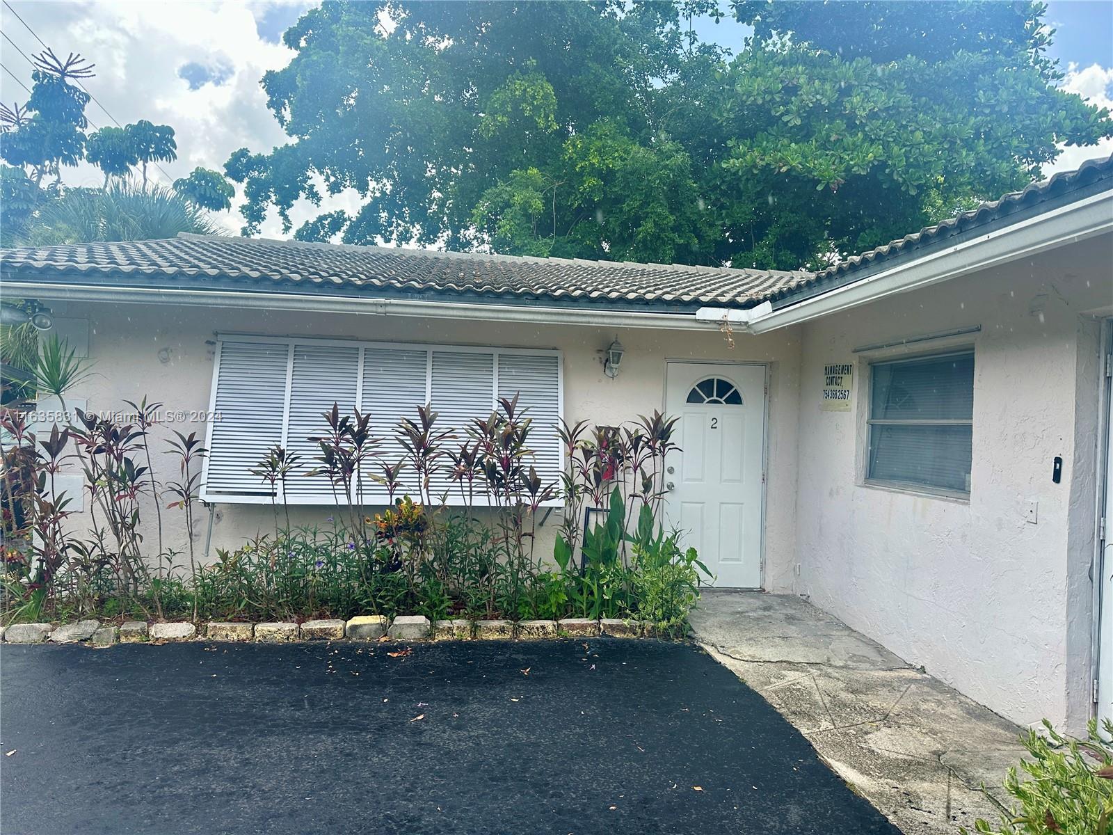 a front view of a house with lots of trees in the background