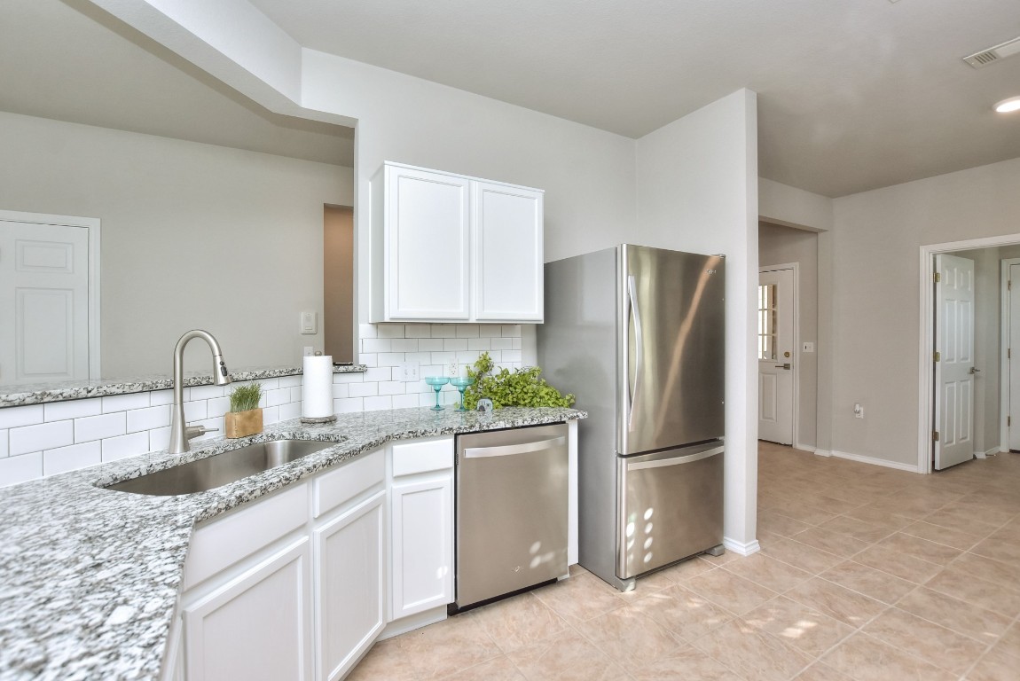 a kitchen with stainless steel appliances granite countertop a refrigerator and a sink