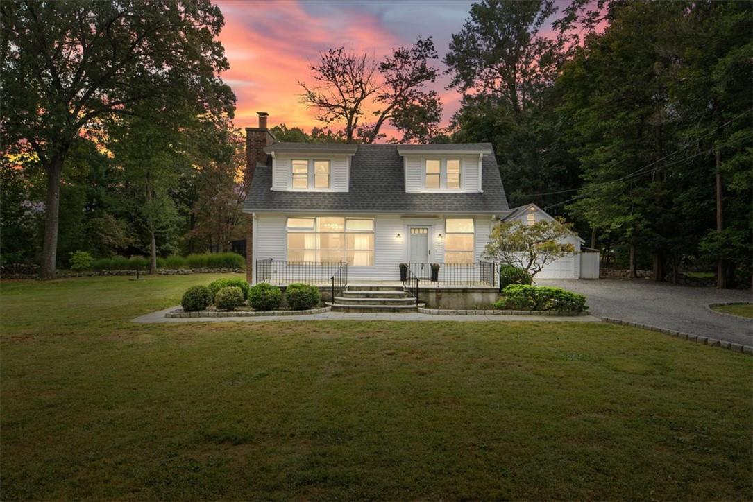 a front view of a house with a yard and trees