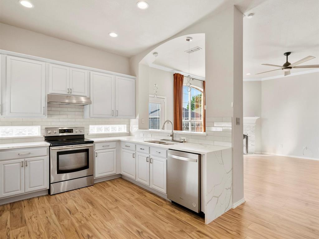 a kitchen with stainless steel appliances granite countertop a sink and a stove