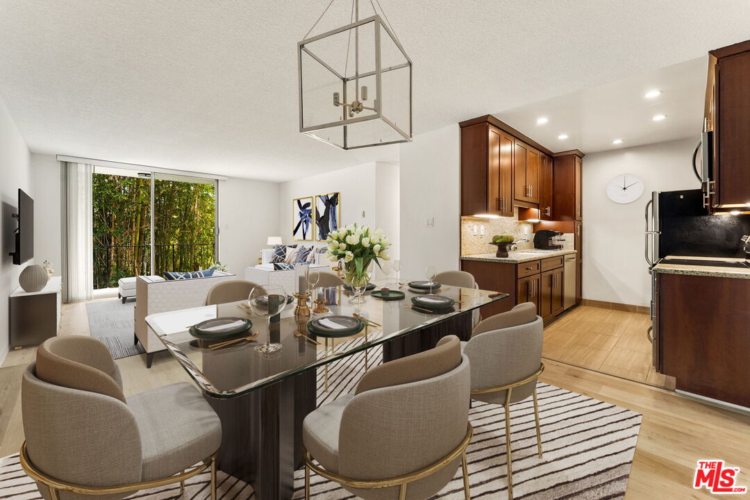 a view of a dining room with furniture a kitchen and chandelier