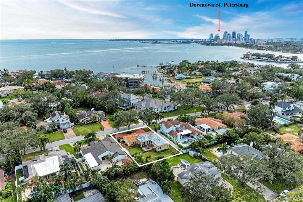 an aerial view of a city with lots of residential buildings ocean and mountain view in back