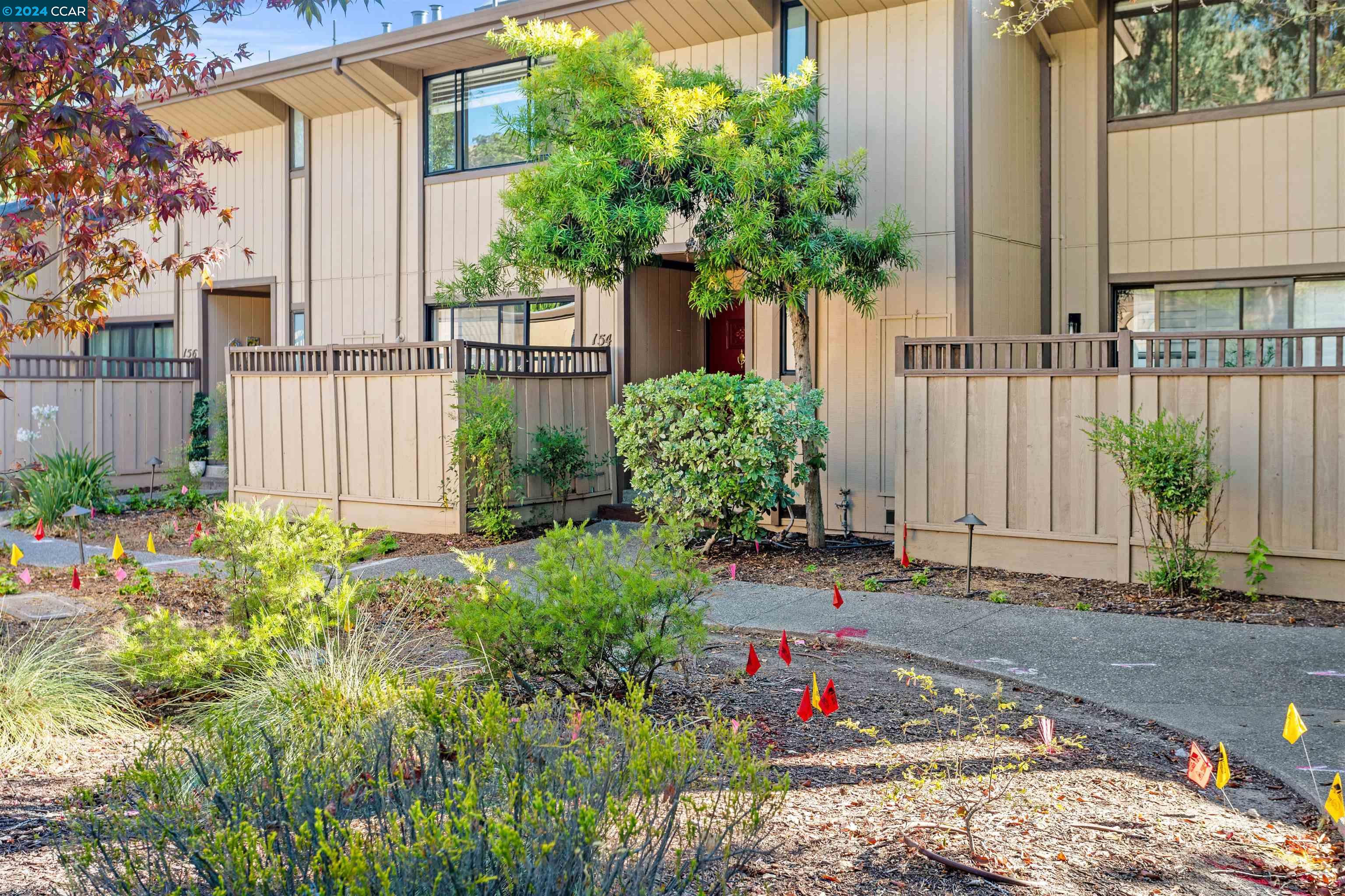 a front view of a house with a yard and plant