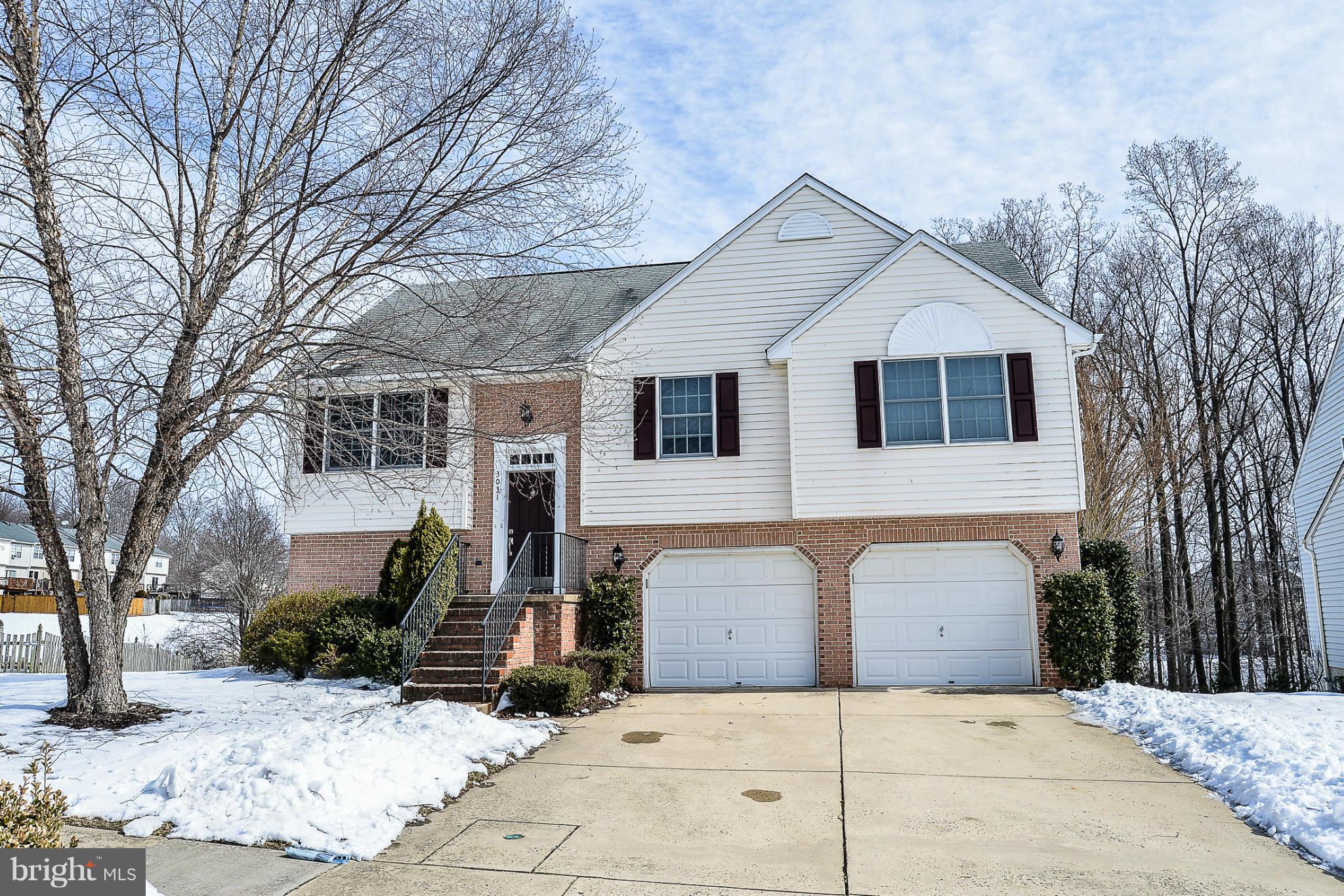 a front view of a house with a yard covered in snow