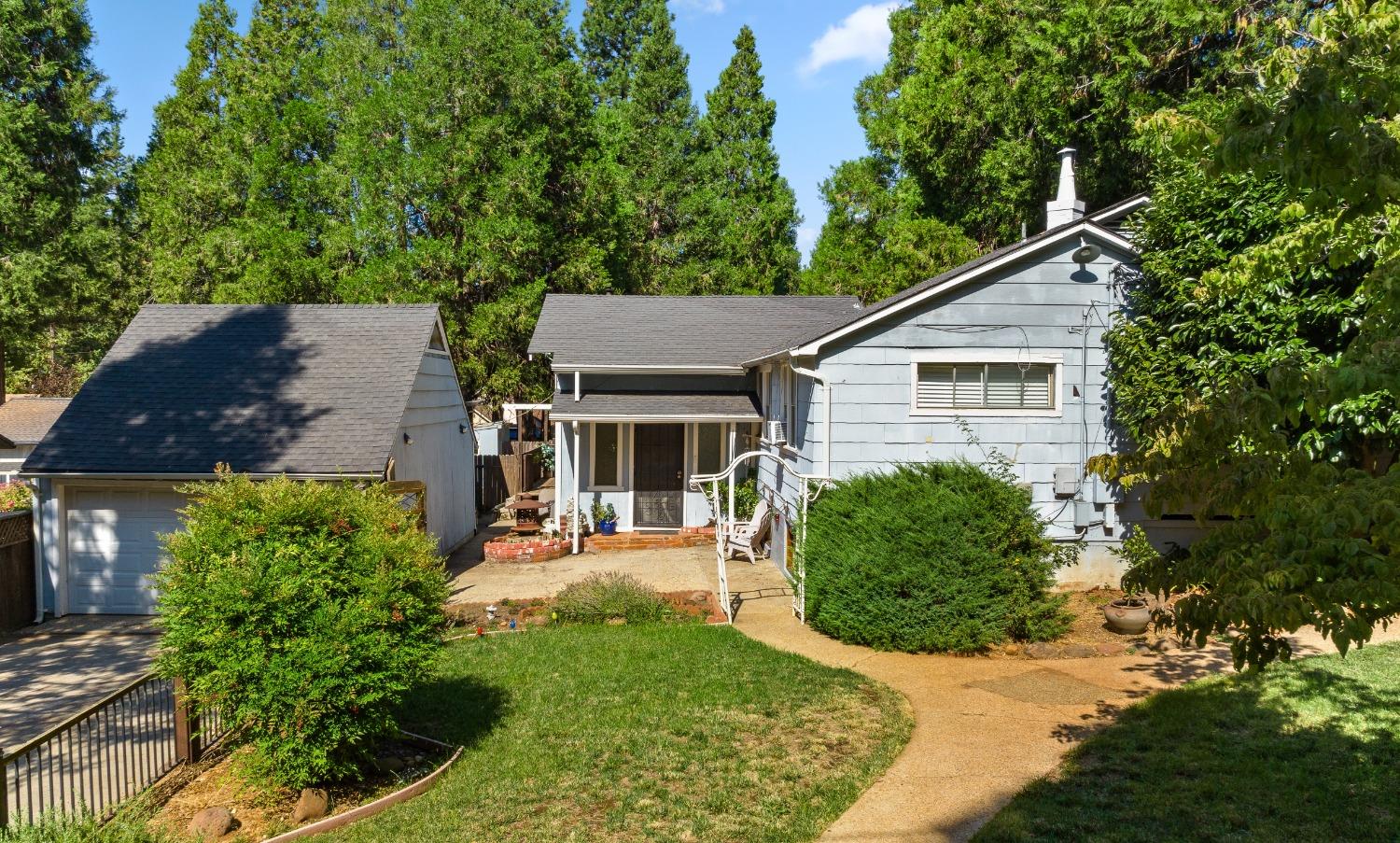 a view of a house with a yard and potted plants