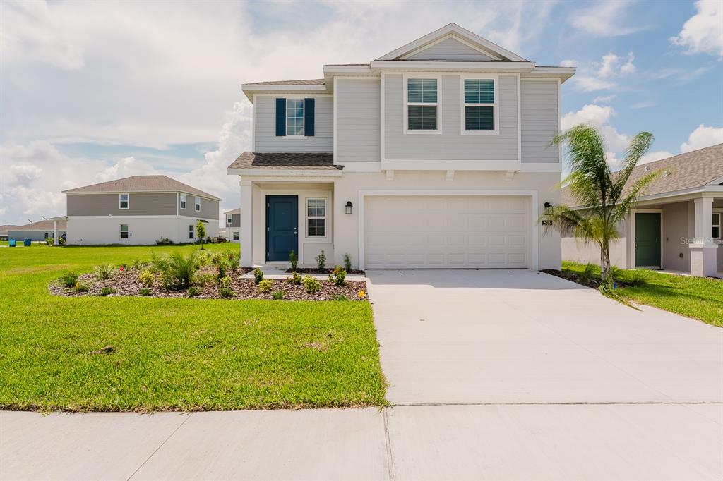 a front view of a house with a yard and garage