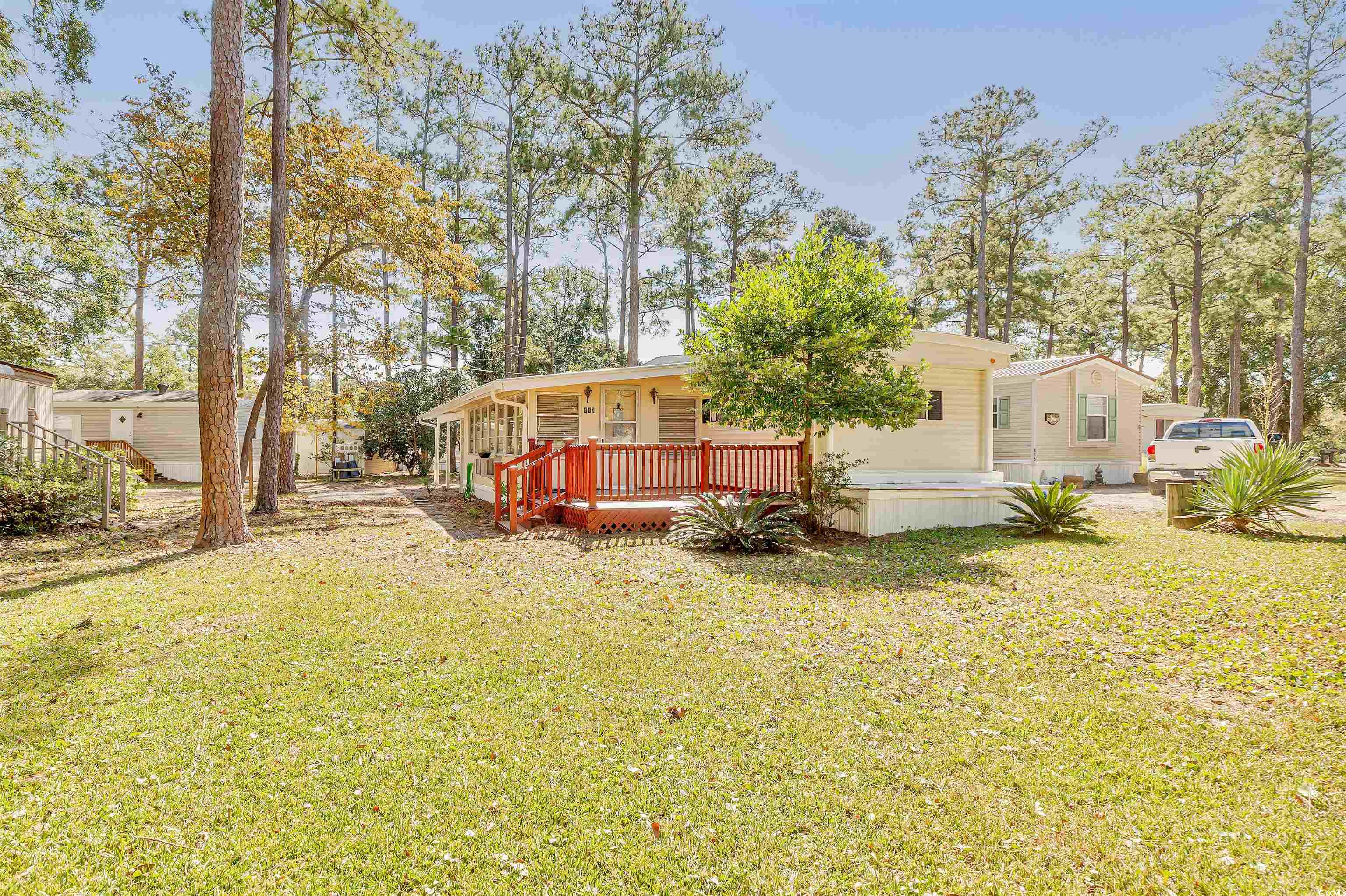 Rear view of property with a wooden deck and a yar