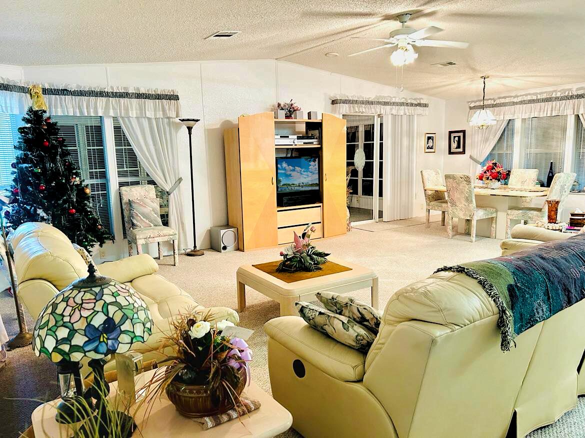 a living room with patio furniture and a chandelier