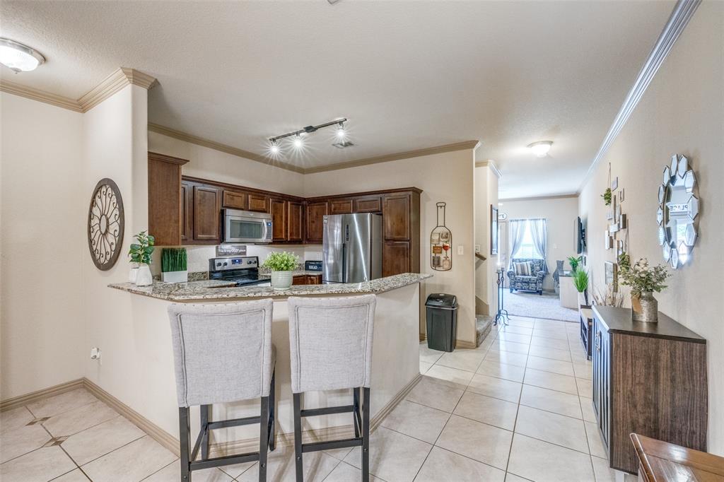 a kitchen with stainless steel appliances granite countertop a refrigerator and a stove top oven