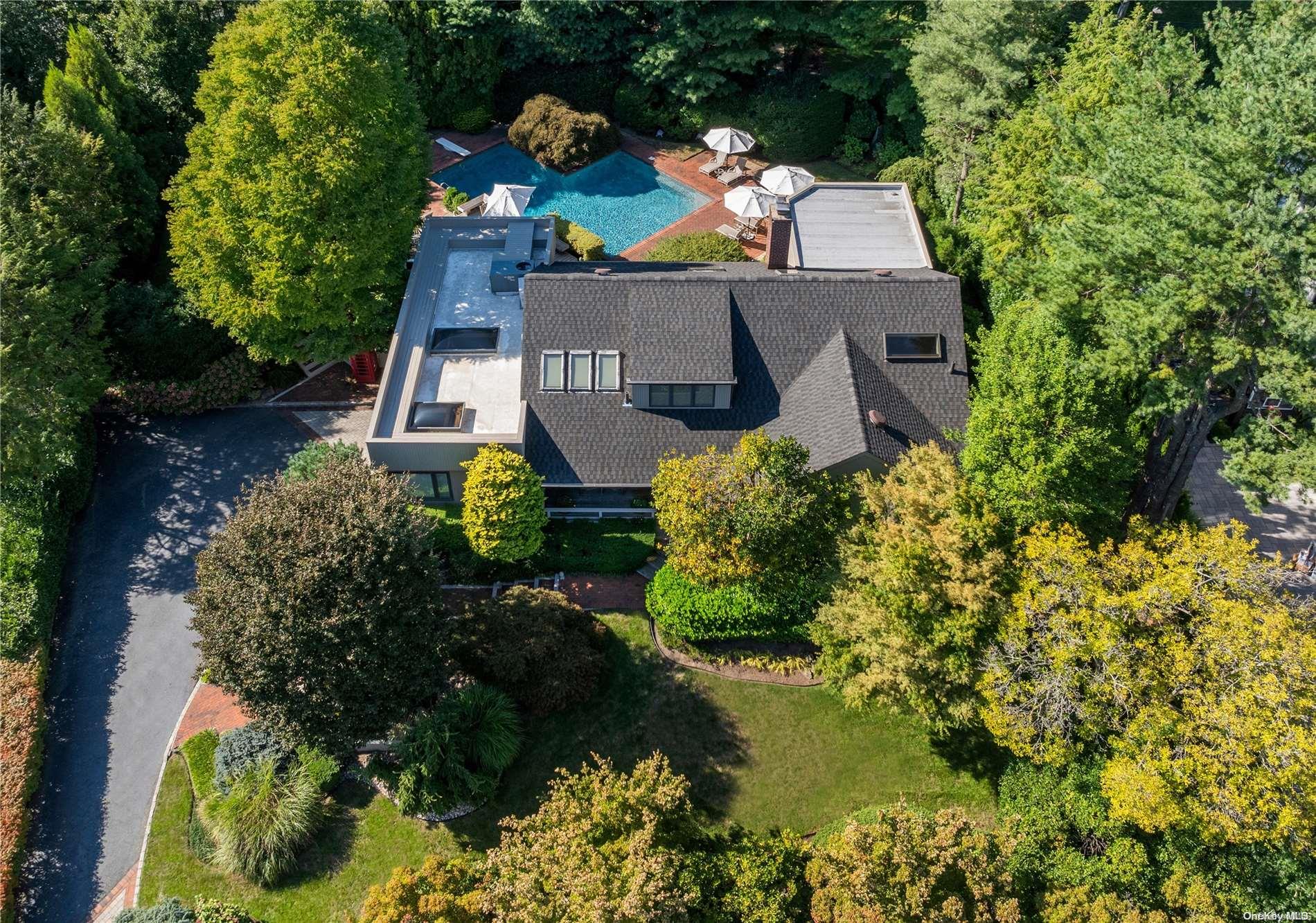 an aerial view of a house with a yard and a large tree