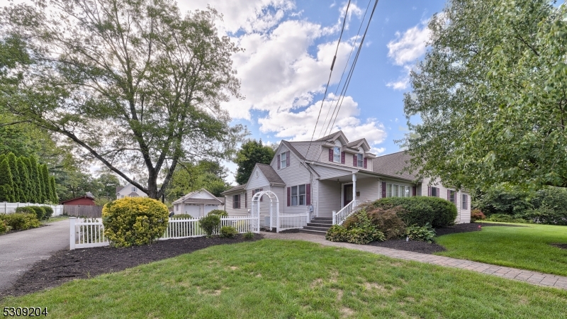 a view of a house with a big yard plants and large trees