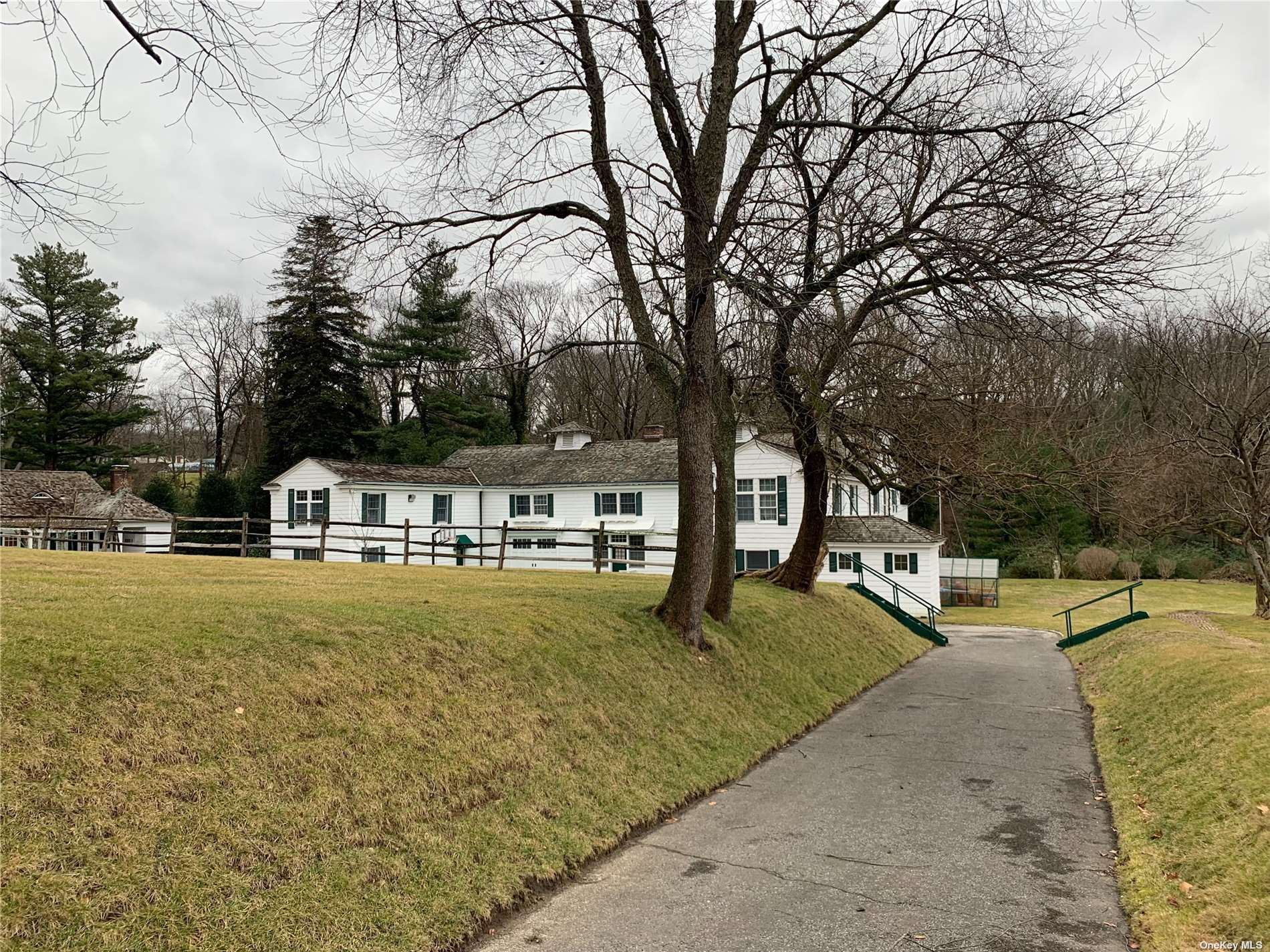 a front view of a house with a yard and trees