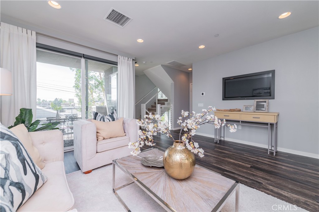 a living room with furniture a flat screen tv and a large window