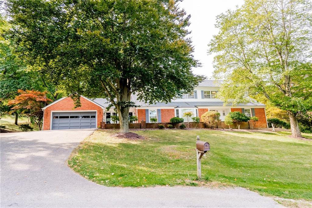 a front view of a house with a yard and trees