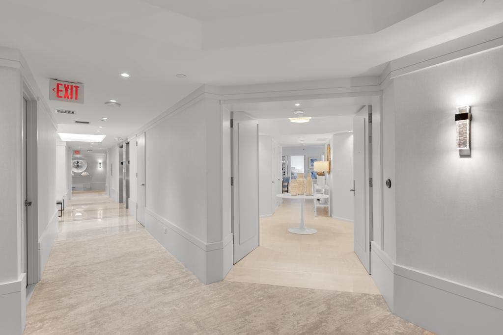 a view of a hallway with wooden floor and a living room