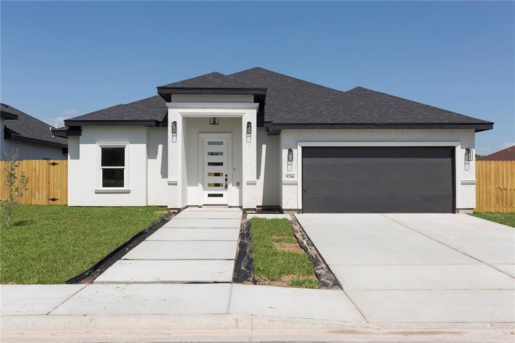 Stucco home with a 2 car garage and a front yard