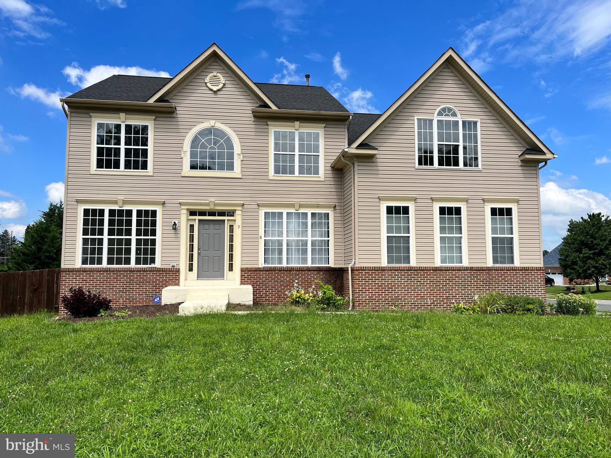 a front view of a house with a yard and plants