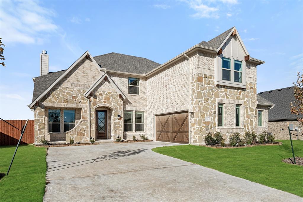 a front view of a house with a yard and trees