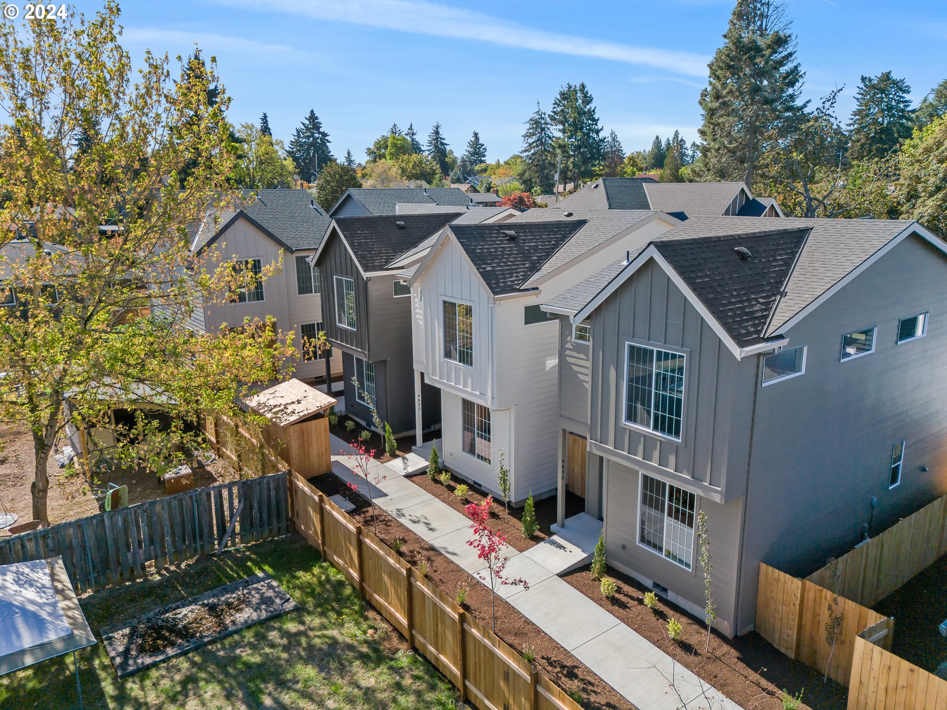 a aerial view of a house with a big yard plants and large tree