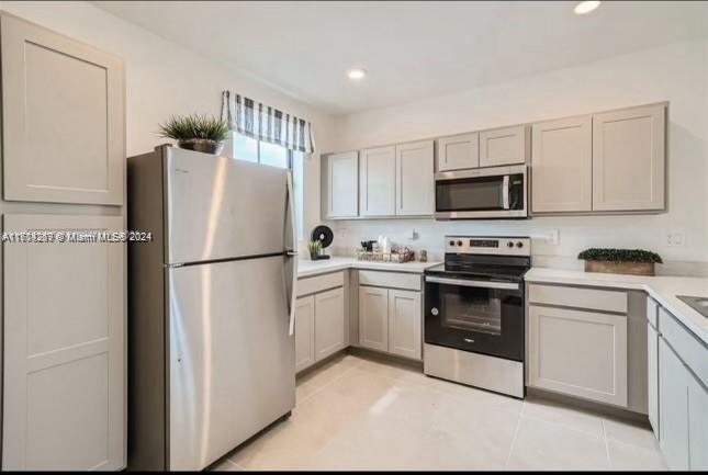 a kitchen with cabinets stainless steel appliances and a refrigerator