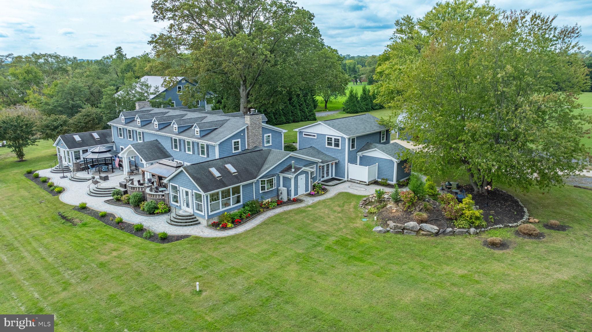 a aerial view of a house with a big yard and large trees