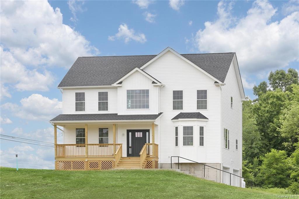 View of front of property featuring a front yard and covered porch