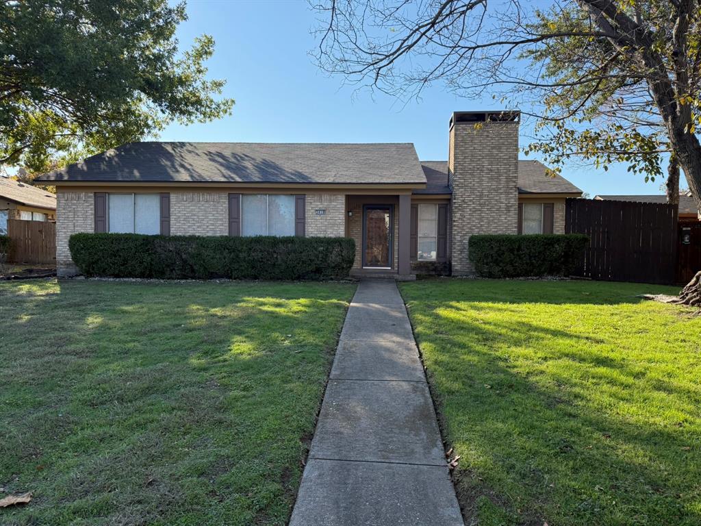 a front view of a house with a garden and yard