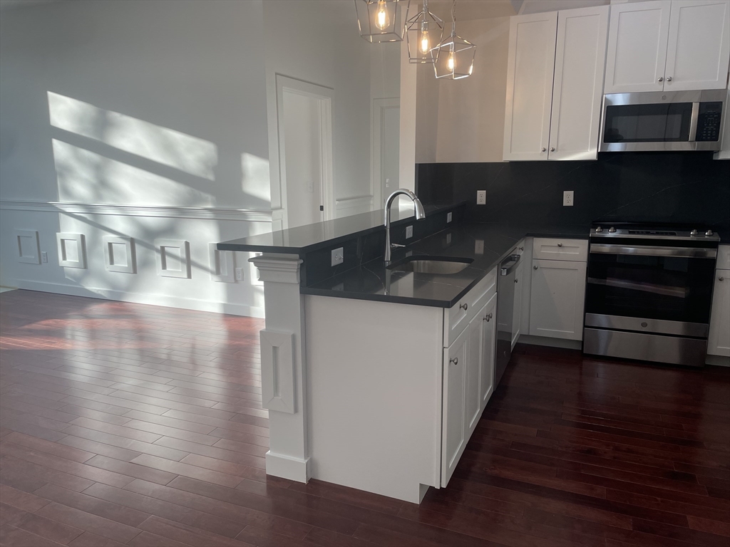 a kitchen with granite countertop a stove and a sink