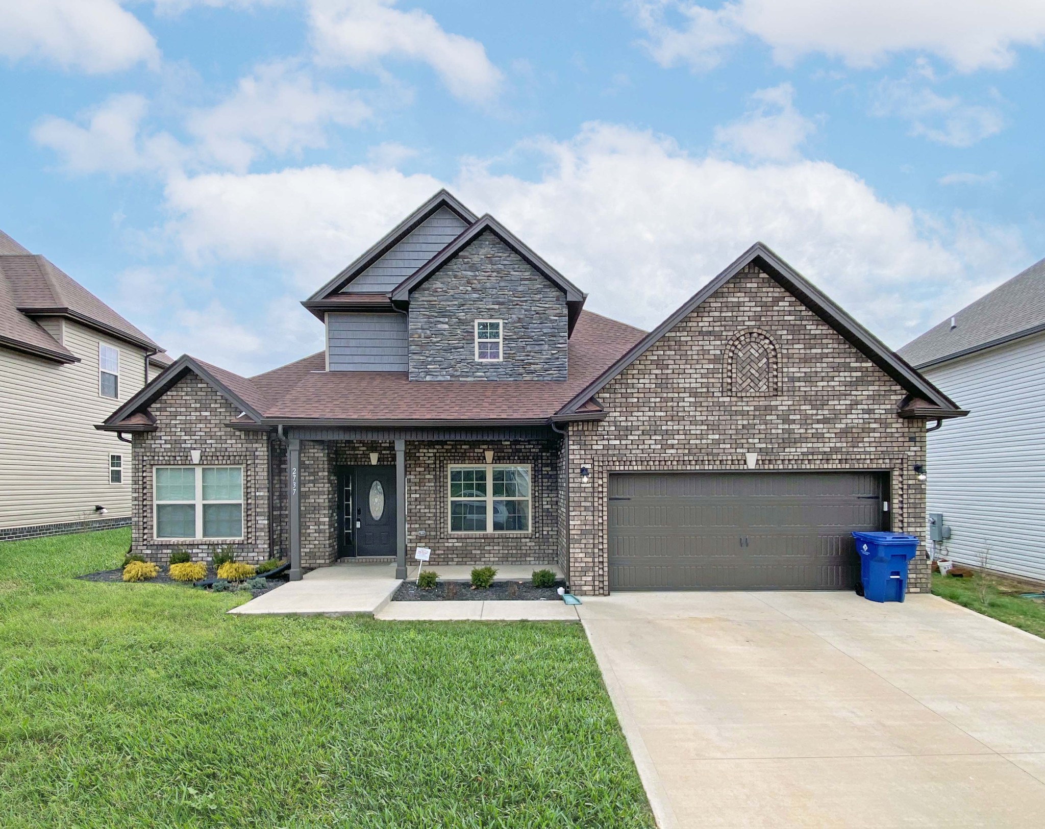 a front view of a house with a yard and garage