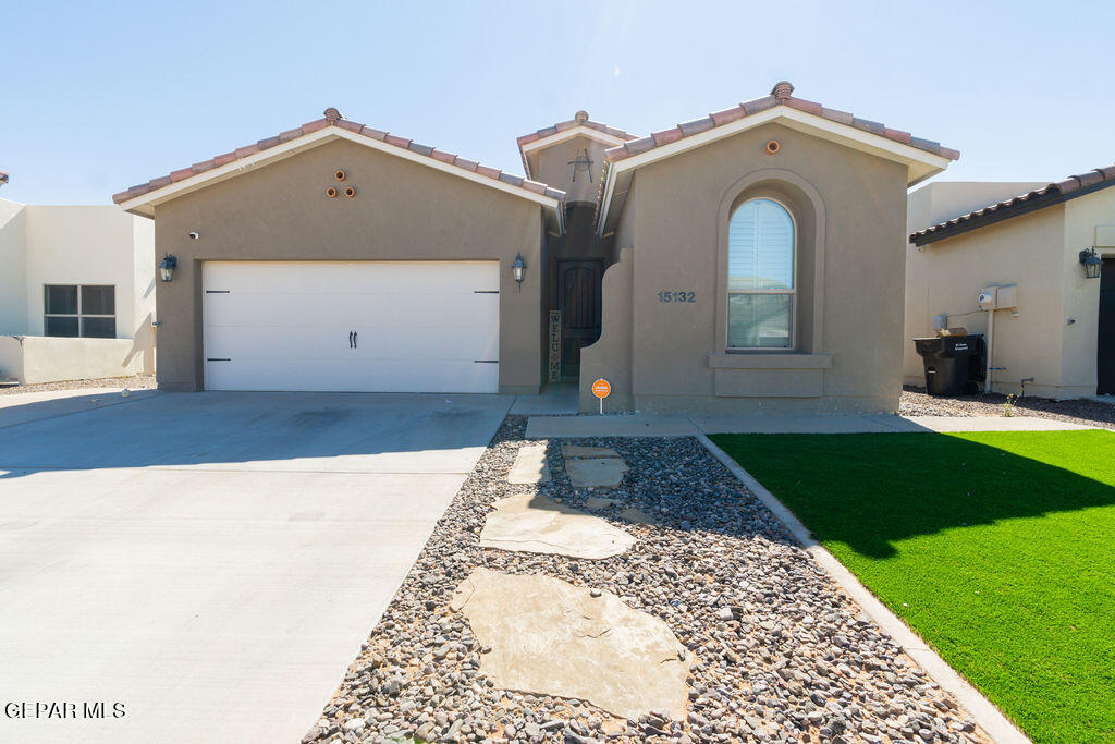 a view of a grey house with a small yard