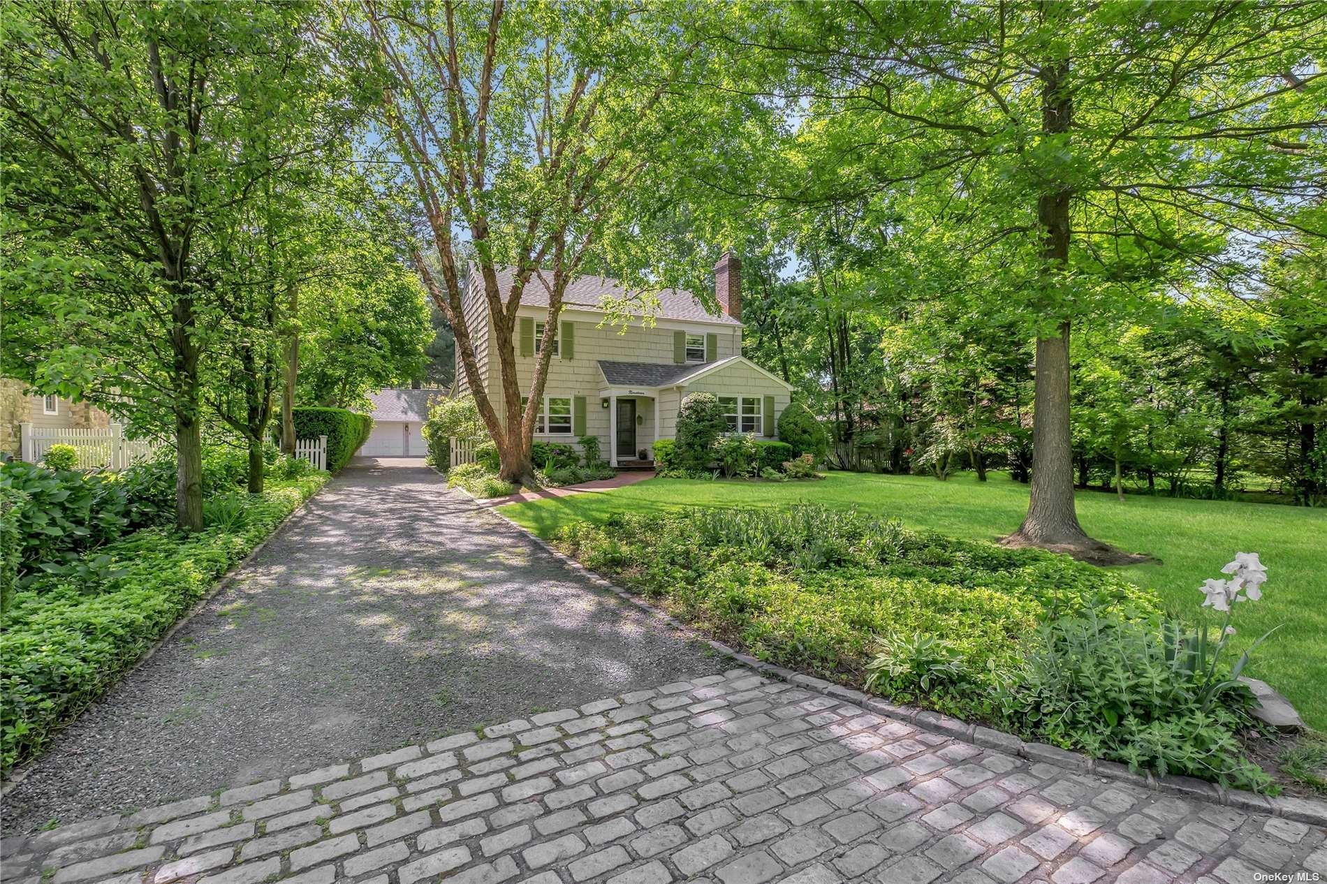 a front view of a house with yard and green space