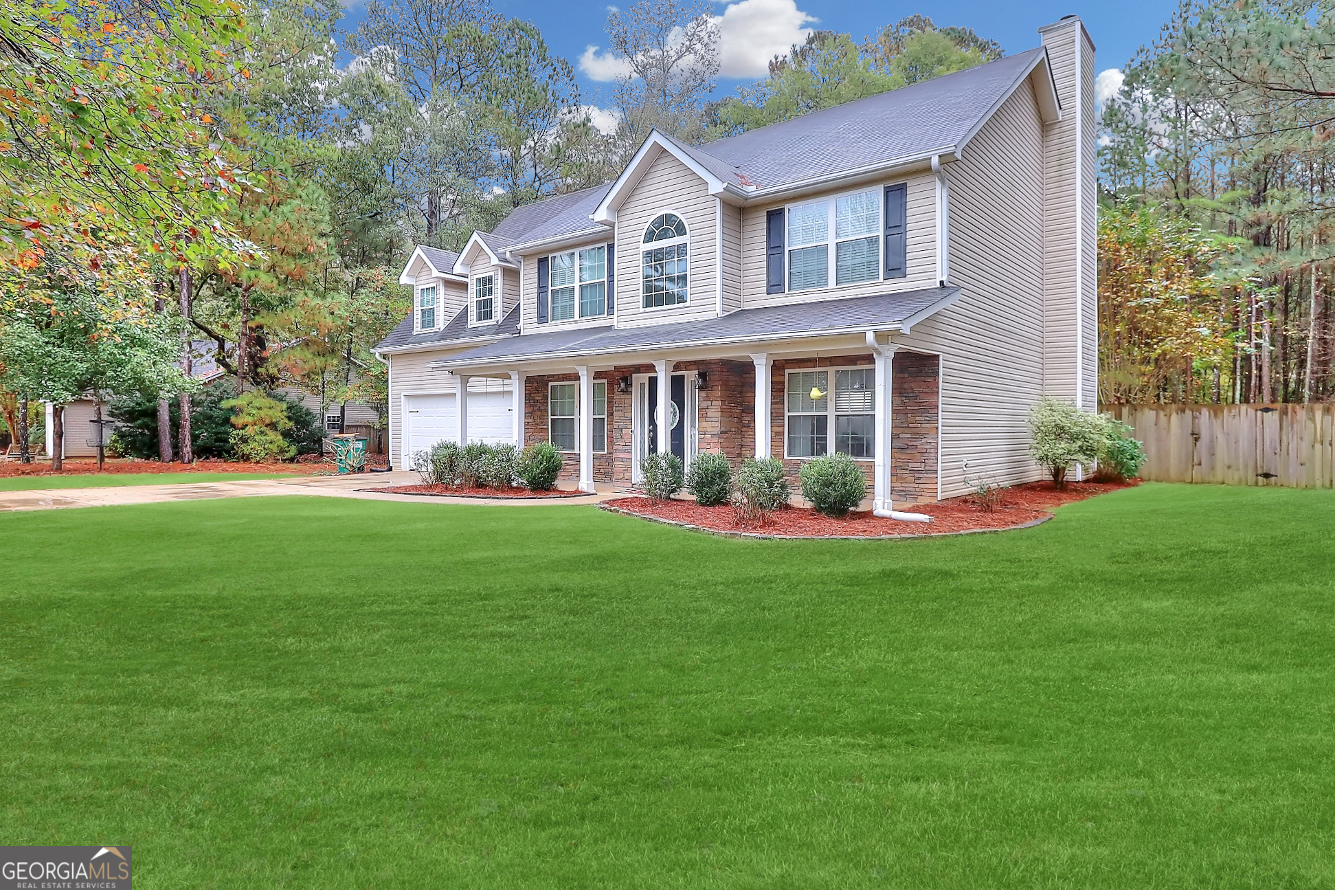 a front view of a house with a yard and green space