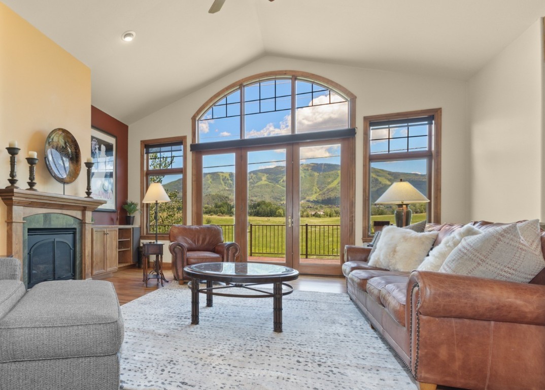 a living room with furniture a fireplace and a floor to ceiling window