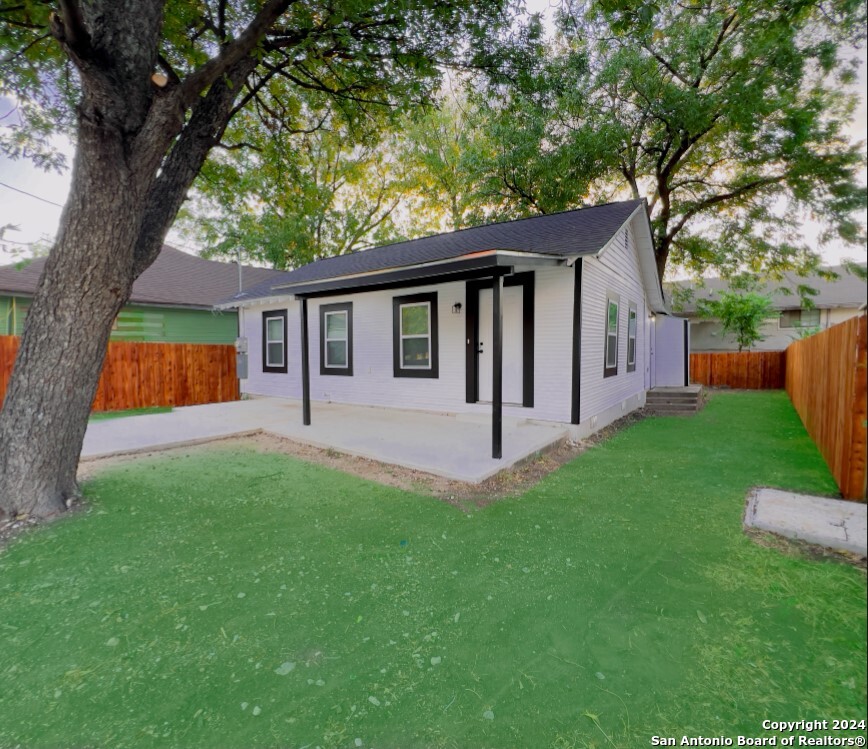 a view of a house with backyard and a tree